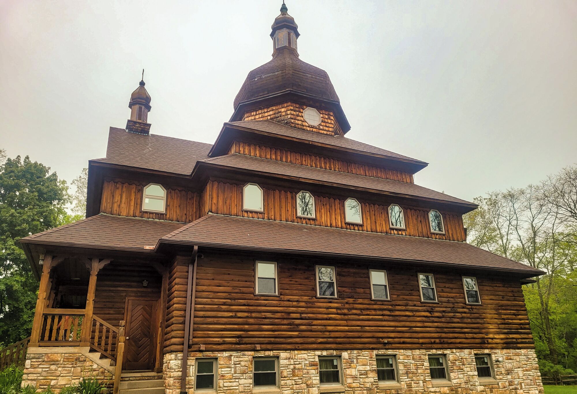 A large wooden log cabin with a prominent tower and multiple windows.. Peaceful retreat above the Delaware River