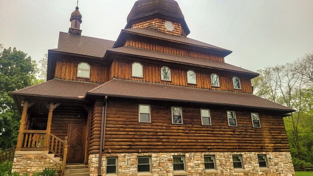 A large wooden log cabin with a prominent tower and multiple windows. - Peaceful retreat above the Delaware River (Pond Eddy)