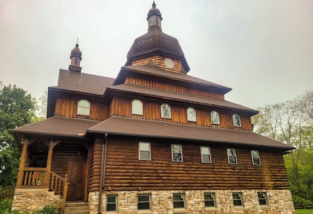 A large wooden log cabin with a prominent tower and multiple windows.. Peaceful retreat above the Delaware River