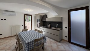 Una cucina moderna con zona pranzo, forno integrato e un'ampia finestra.