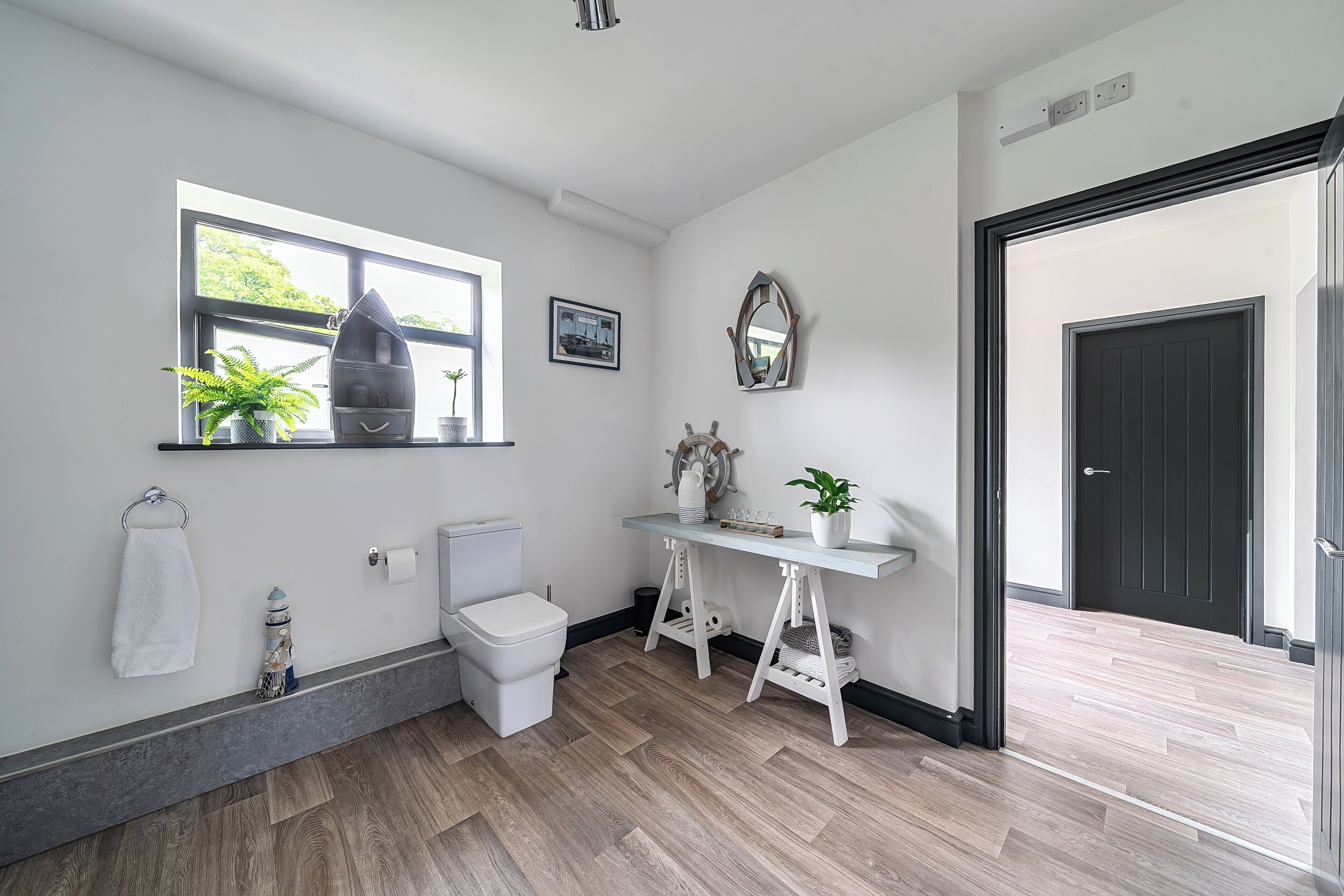 A bathroom with a toilet, sink, and window.