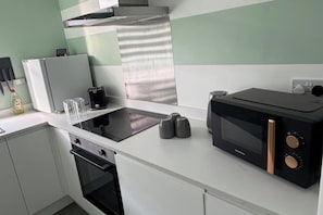 Eine Küche mit Mikrowelle, Toaster und Backofen.