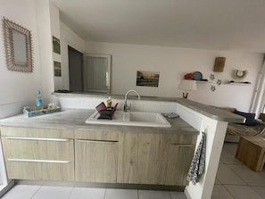 Una cocina moderna con una isla grande, un fregadero doble y armarios de madera.