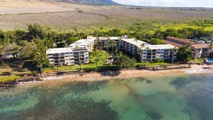 Um hotel à beira-mar com vários edifícios, praia e águas cristalinas.