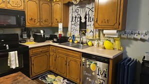 Una cucina con mobili in legno, un forno a microonde, un lavello e una lavastoviglie.