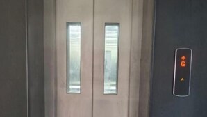 Un ascensor con un panel de control que muestra una flecha verde hacia arriba y la letra 'G'.