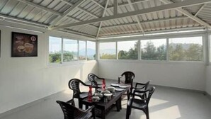 Una habitación amplia con techos altos, ventanas grandes y una mesa con sillas.