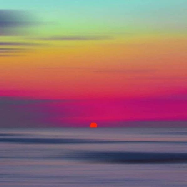 Un coucher de soleil sur une Ă©tendue dâeau calme.