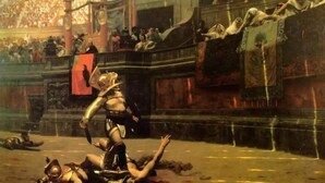 En historisk scen med en central gestalt i rustning, en folkmassa i bakgrunden och klassisk arkitektur.