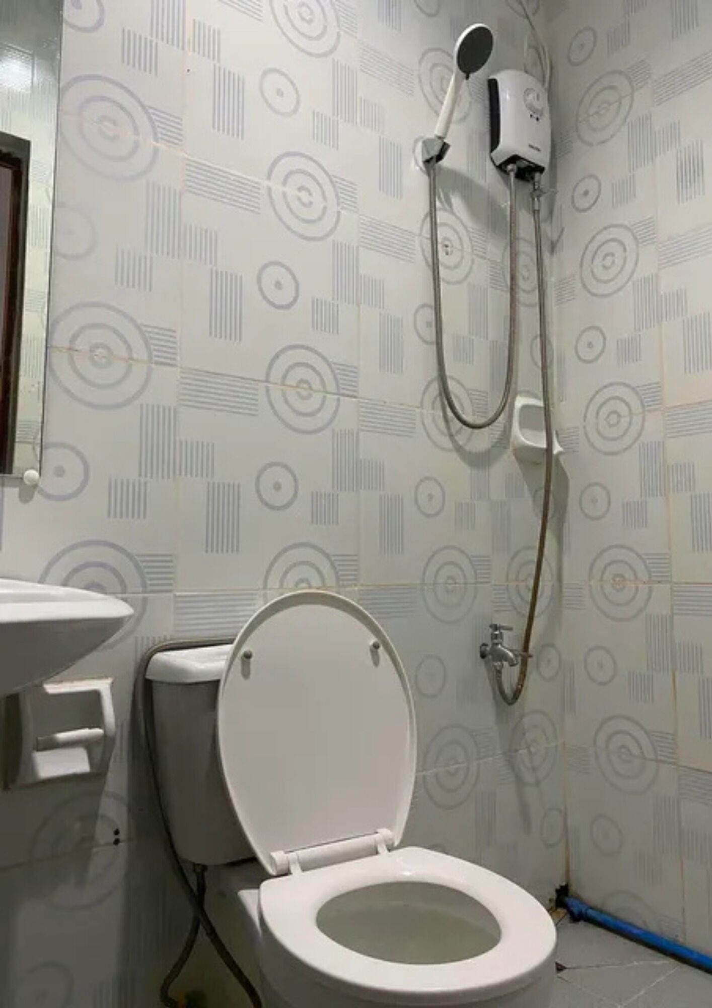 A bathroom with a toilet, a sink, and a shower unit.