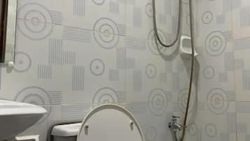A bathroom with a toilet, a sink, and a shower unit.