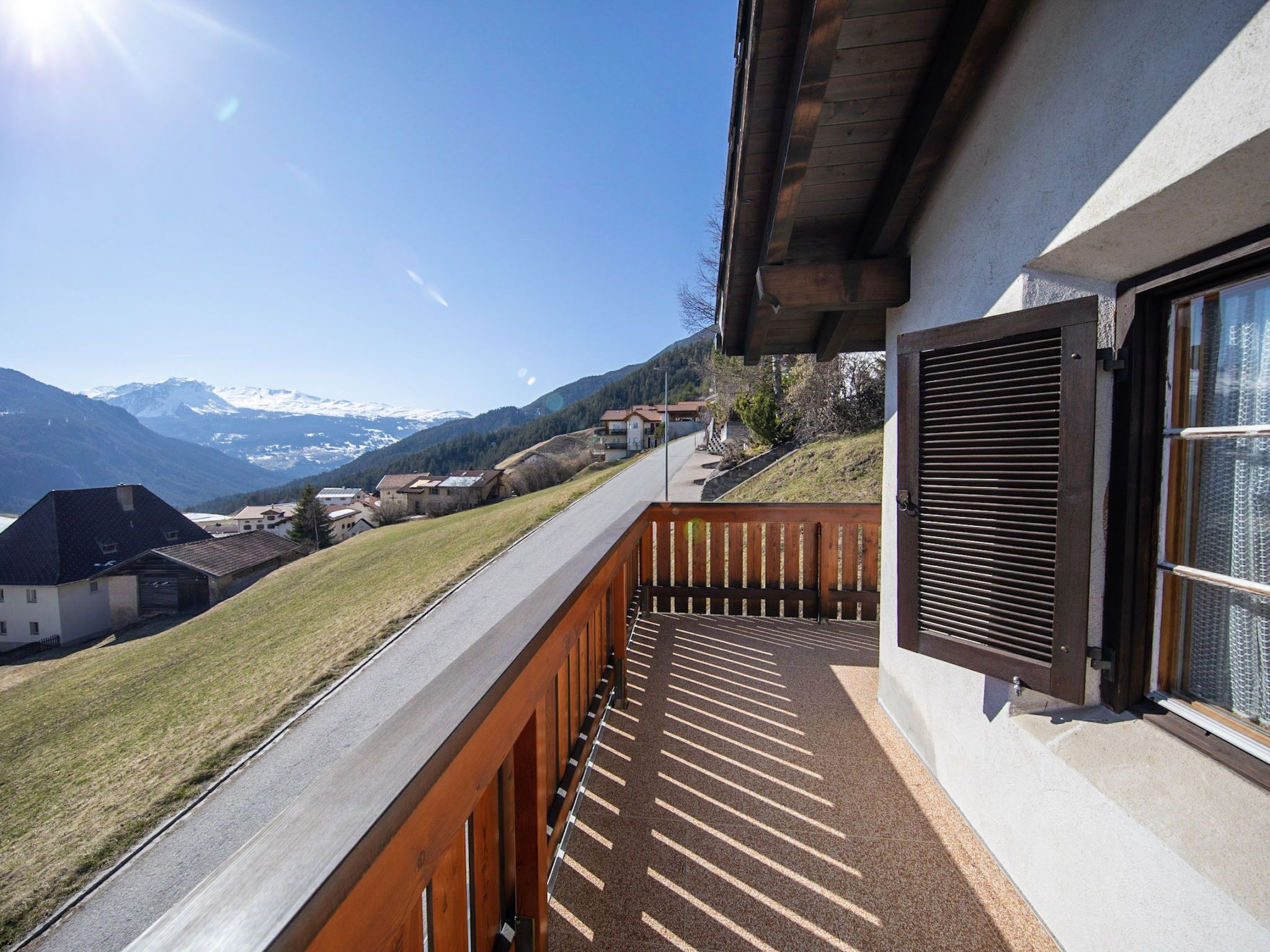 Un balcon offrant une vue sur une chaîne de montagnes et un ciel dégagé.