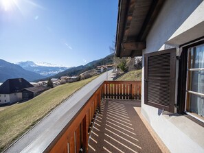 A balcony with a view of a mountain range and a clear sky.