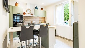 Una cocina moderna con comedor, un reloj y una ventana con vistas.