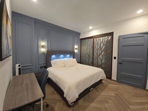 Un dormitorio con una cama, un escritorio y un armario.