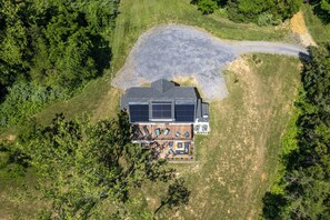 Eine Vogelperspektive auf ein Haus mit einer Terrasse, Solaranlagen und einem Swimmingpool.