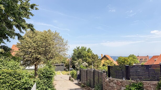 A pathway leading to a building with a stone wall and a wooden fence. - Amazing home in Allinge with WiFi (Allinge)