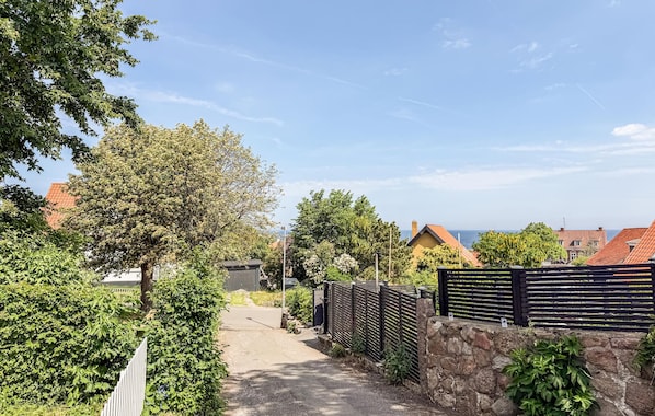 A pathway leading to a building with a stone wall and a wooden fence. - Amazing home in Allinge with WiFi (Allinge)