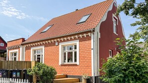A red brick house with two windows, a white picket fence, and a small garden. - Amazing home in Allinge with WiFi (Allinge)