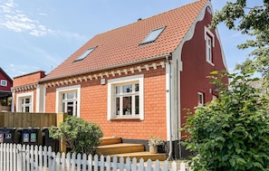 A red brick house with two windows, a white picket fence, and a small garden. - Amazing home in Allinge with WiFi (Allinge)