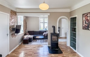 A modern living room with a fireplace, a sofa, a TV, and a dining area. - Amazing home in Allinge with WiFi (Allinge)
