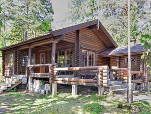 A log cabin with a porch, large windows, and a chimney. - Kariniemi by Interhome (Lohja)