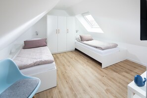 Ein modernes, minimalistisches Schlafzimmer mit Hochbett, Schreibtisch und Stuhl.