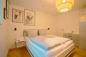 Ein Schlafzimmer mit Bett, Nachttischen, einem Schminktisch und Bildern an der Wand.