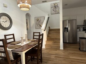 A dining area with a wooden table, chairs, and a large wall clock. - 4-bedroom house in wonderful Davenport Resort Exclusive (Davenport)