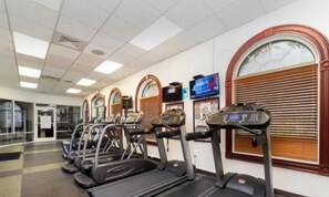 A gym with treadmills, exercise bikes, and a television screen. - 4-bedroom house in wonderful Davenport Resort Exclusive (Davenport)