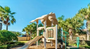 A playground with a slide, climbing structures, and palm trees in the background. - 4-bedroom house in wonderful Davenport Resort Exclusive (Davenport)