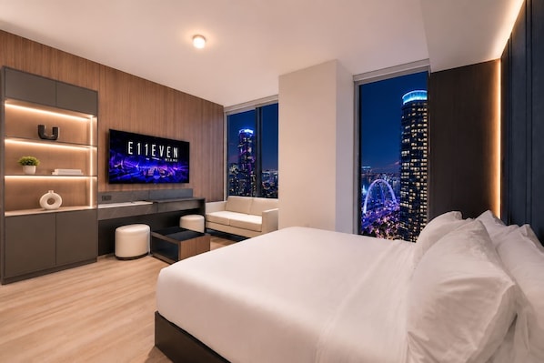 A modern hotel room with a large bed, a TV, a desk, and a city view. - Luxury E11EVEN Residence with ELITE AMENITIES (Miami)