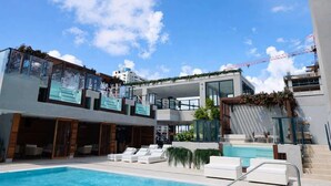 Un hôtel moderne doté d’une piscine, d’un espace extérieur aménagé et offrant une vue sur le panorama urbain.
