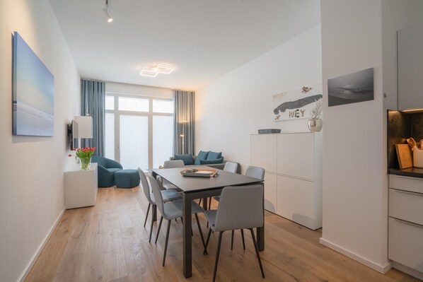 Ein moderner Wohnraum mit Essbereich, Küche und Sitzgelegenheit.