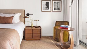 A modern hotel room with a bed, bedside table, lamp, chair, and two framed pictures on the wall. - Domaine De Cocagne N°3 - Pool & Sea View, Cagnes sur Mer, France (Cagnes sur Mer)