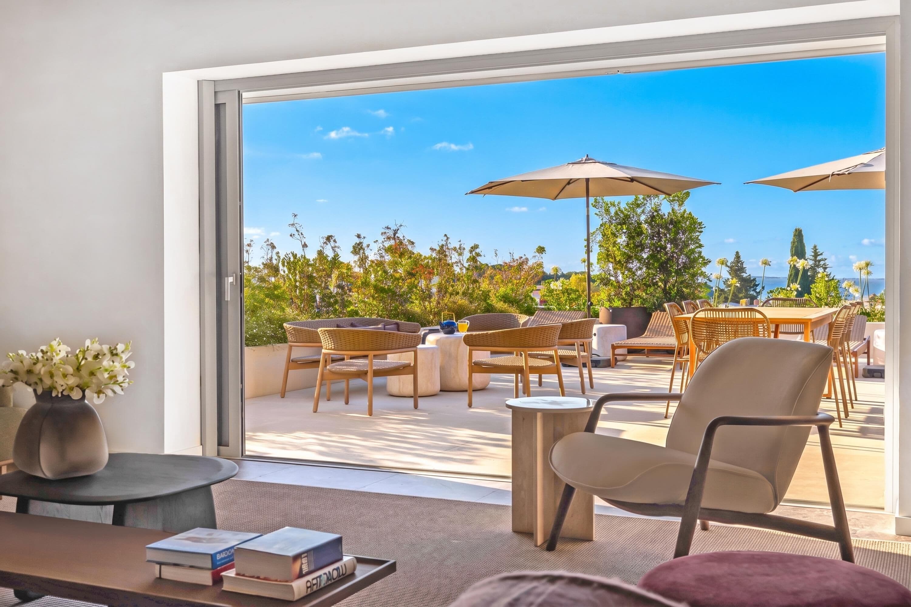 A modern living room with a large sliding glass door leading to an outdoor patio area.