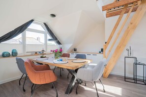Ein Essbereich mit Holztisch, Stühlen und Blick ins Freie.