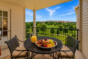 A balcony with a table set for breakfast, a pitcher of orange juice, and a view of a golf course. - Branson Condo with Golf Course View • 3 King Suites • Sleeps 6 (Branson)