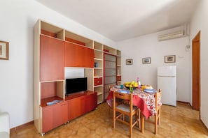 A compact kitchen with a dining table, a television, and a refrigerator. - Leuca Relax&Sea n.8C, Castrignano del Capo, Italy (Castrignano del Capo)