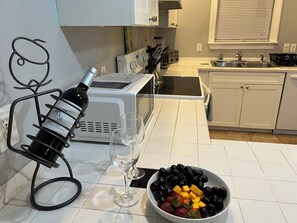 Et køkken med en vinkøler, en skål med frugt og en brødrister.