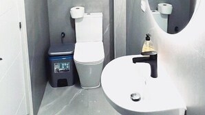 A bathroom with a toilet, sink, and mirror. - Hostal Casa 18 (Madrid)