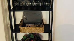 A black metal shelf with wine glasses, a lantern, a plant, and a basket of fruit. -     The Pinery | Modern Retreat with Pool & Family-Friendly Comfort (St. Catharines)