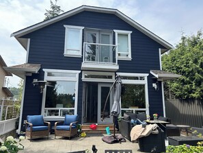 A two-story house with a balcony, wicker furniture, and a patio area. - Stay on Beautiful Glen Lake Victoria (Victoria)