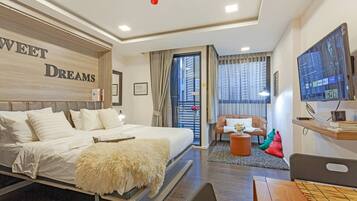 A hotel room with a bed, a TV, a desk, and a chair.