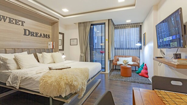 Ein Hotelzimmer mit Bett, Fernseher, Schreibtisch und Stuhl.