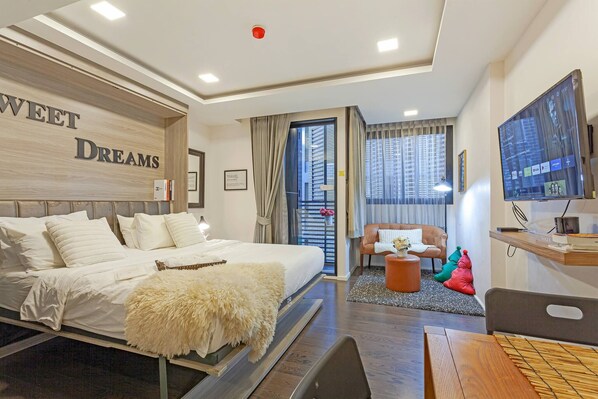 Ein Hotelzimmer mit Bett, Fernseher, Schreibtisch und Stuhl.