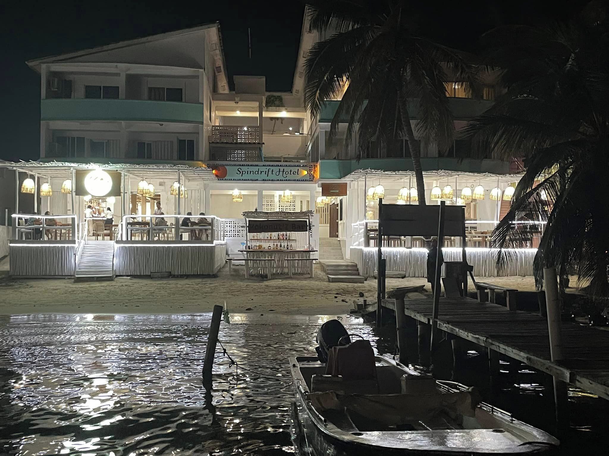 A beachfront hotel with a bar, dining area, and a boat dock.