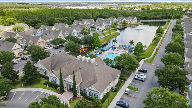 Uma área residencial com casas, piscina e um píer à beira de um lago.