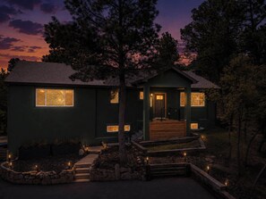A two-story house with a front porch, a small deck, and a stone pathway leading to the entrance. - 4BR Mountain Retreat with Games, Large Deck &Views (Colorado Springs)