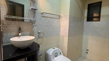 Un baño con lavamanos, inodoro y ducha blancos.